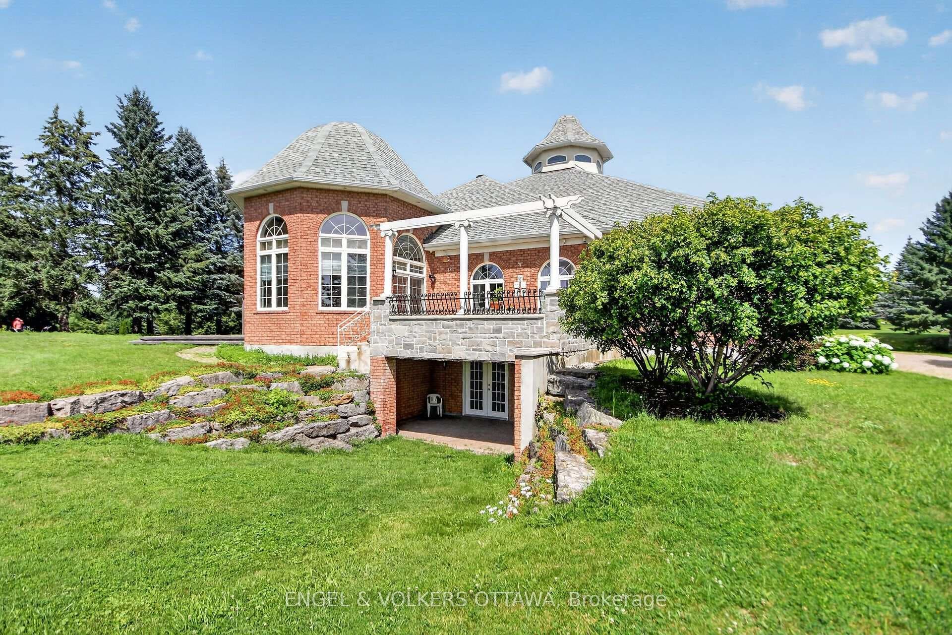 Walkout basement entrance w stone balcony overtop