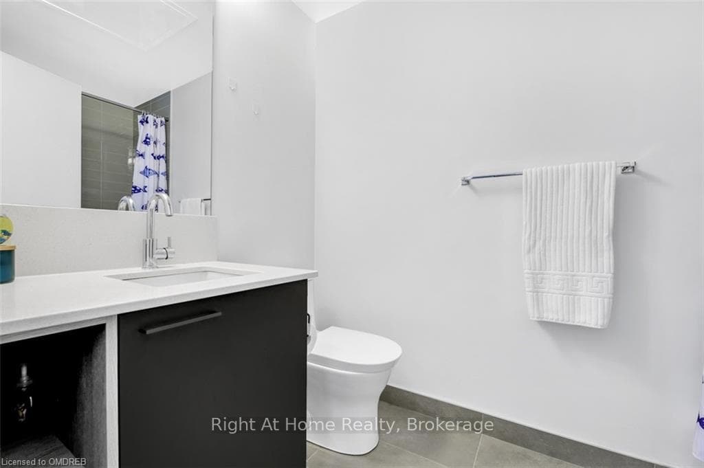 Bathroom featuring toilet, vanity, tile patterned