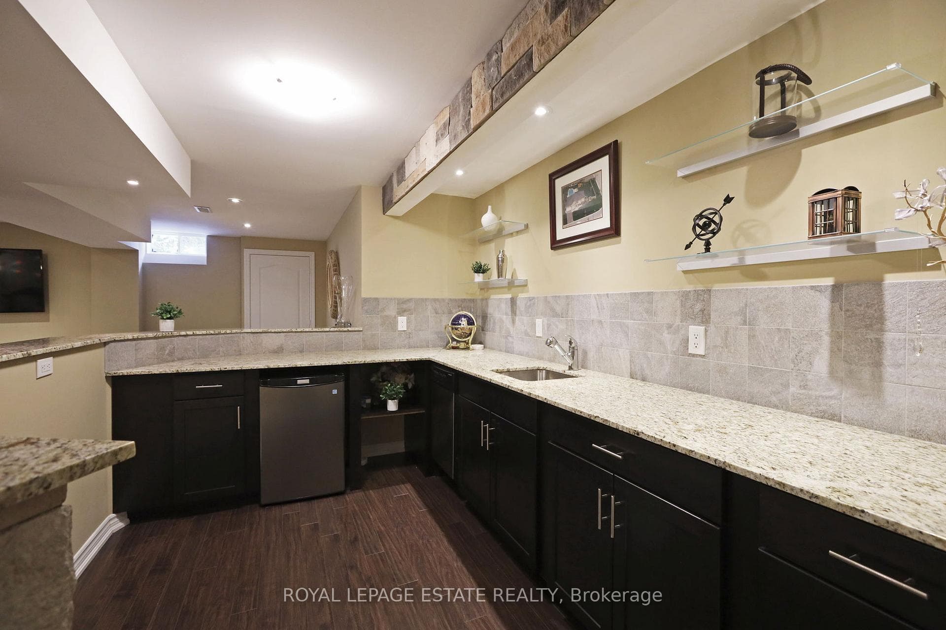 Basement kitchenette with stone counters and sink