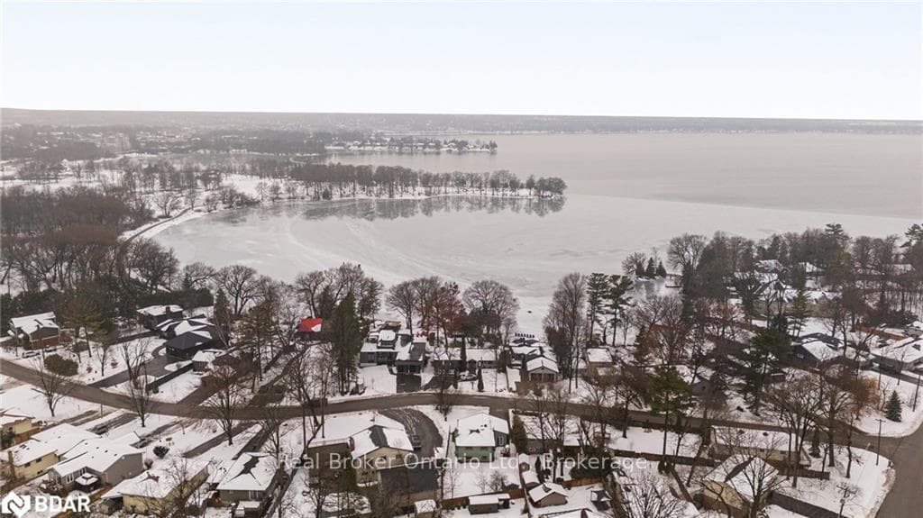Snowy aerial view featuring a water view