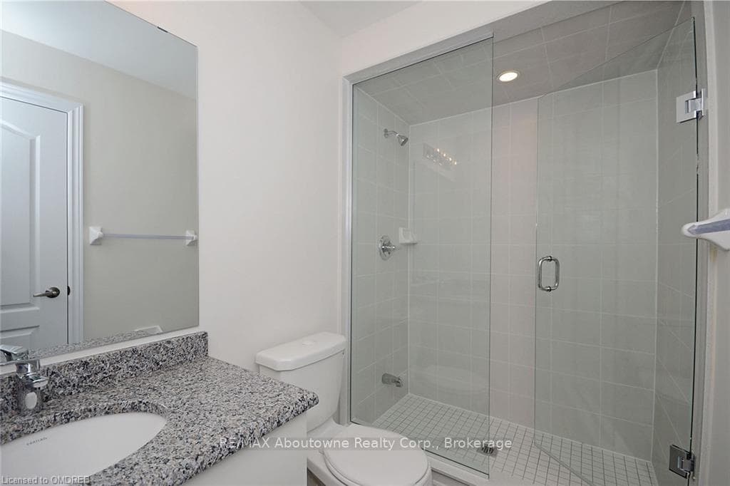Bathroom with a shower with door, vanity, and toil
