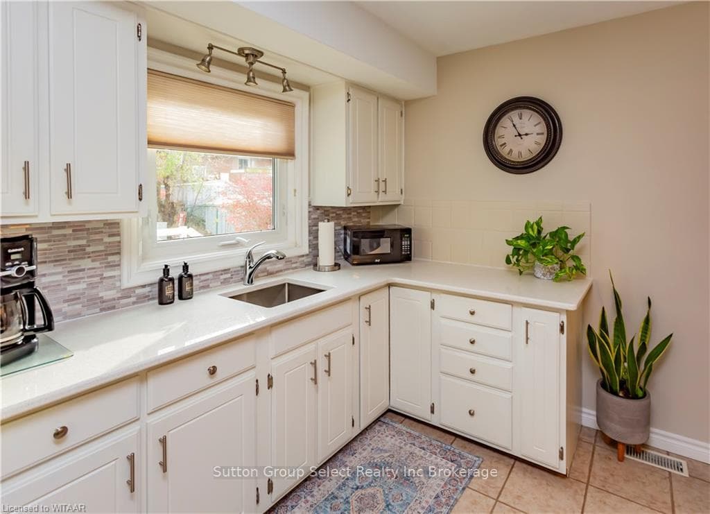 Kitchen with light tile patterned flooring, white