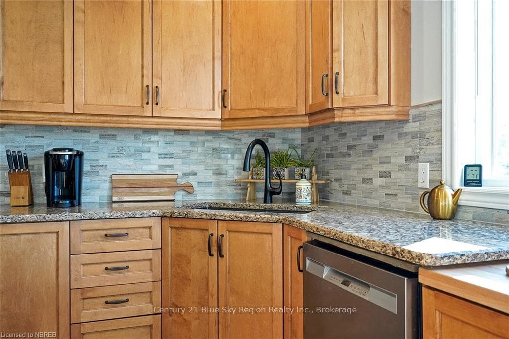 Kitchen with light stone countertops, backsplash,