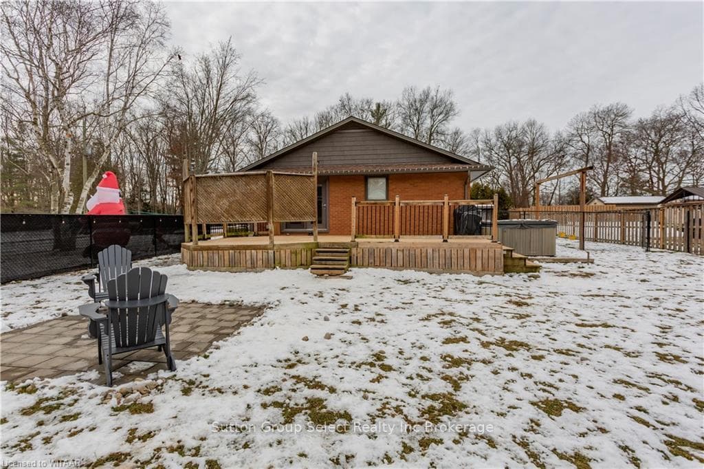Snow covered rear of property with a deck and a ho