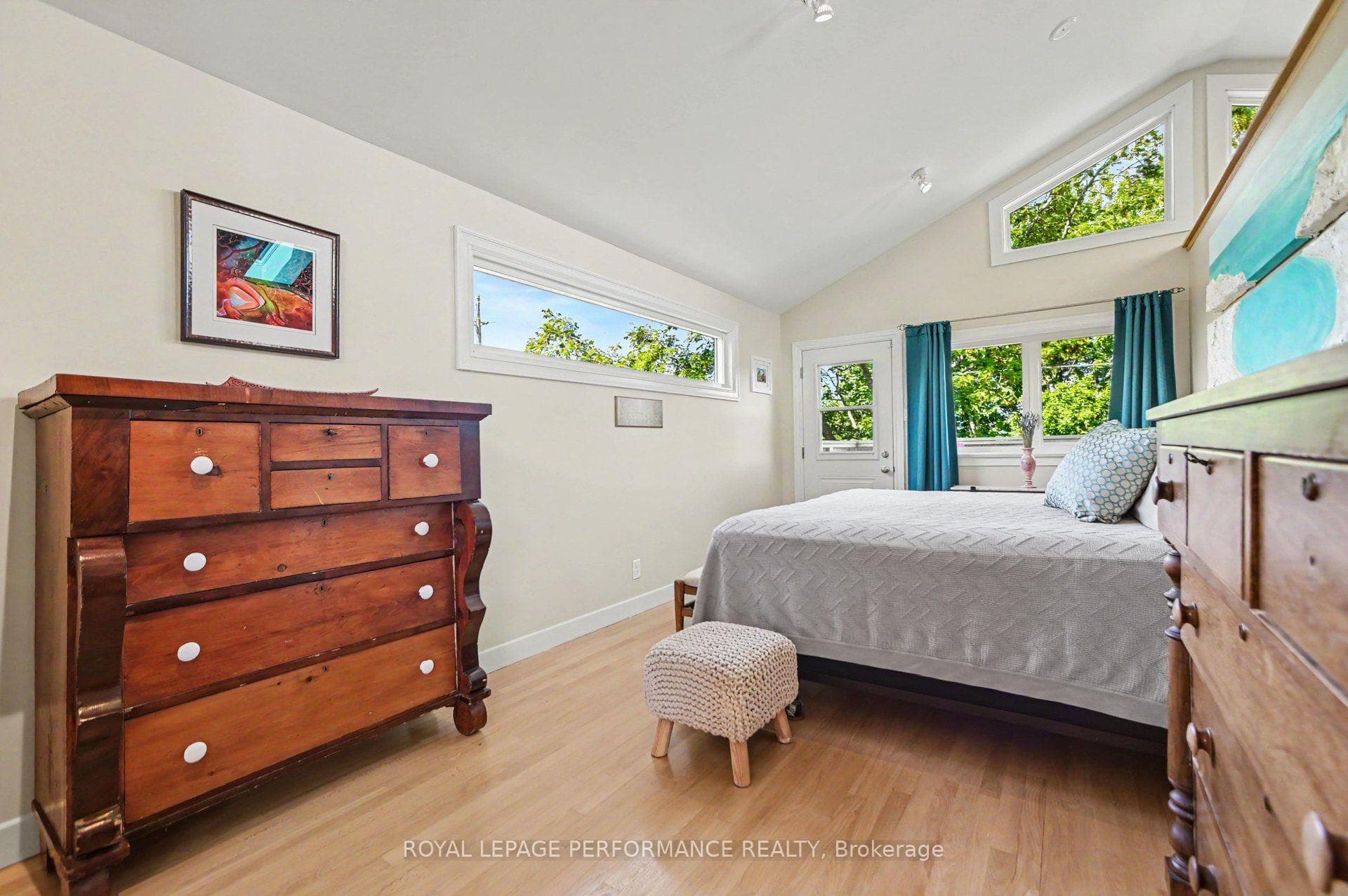 Primary bedroom w/vaulted ceilings and balcony