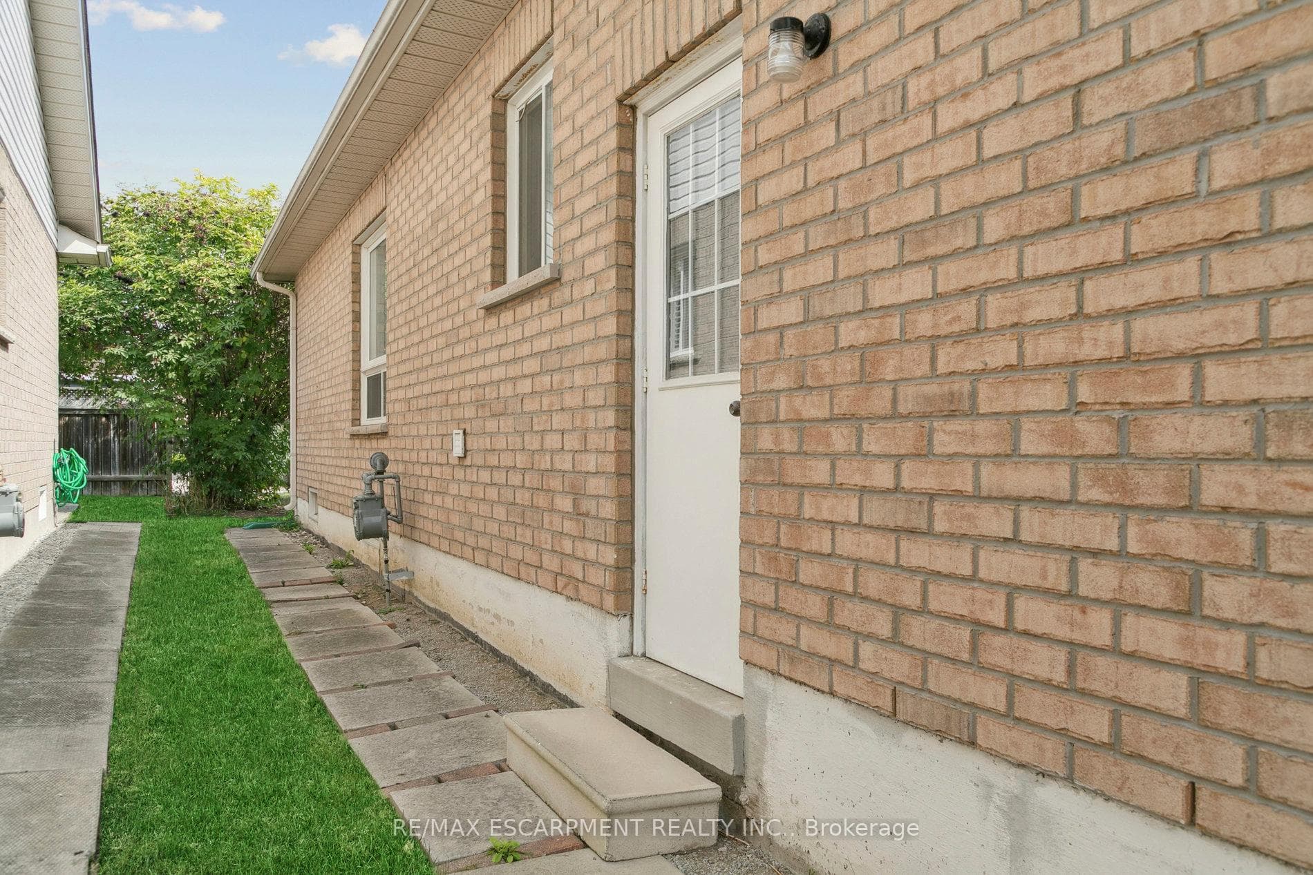 Side door from garage and walkway to backyard