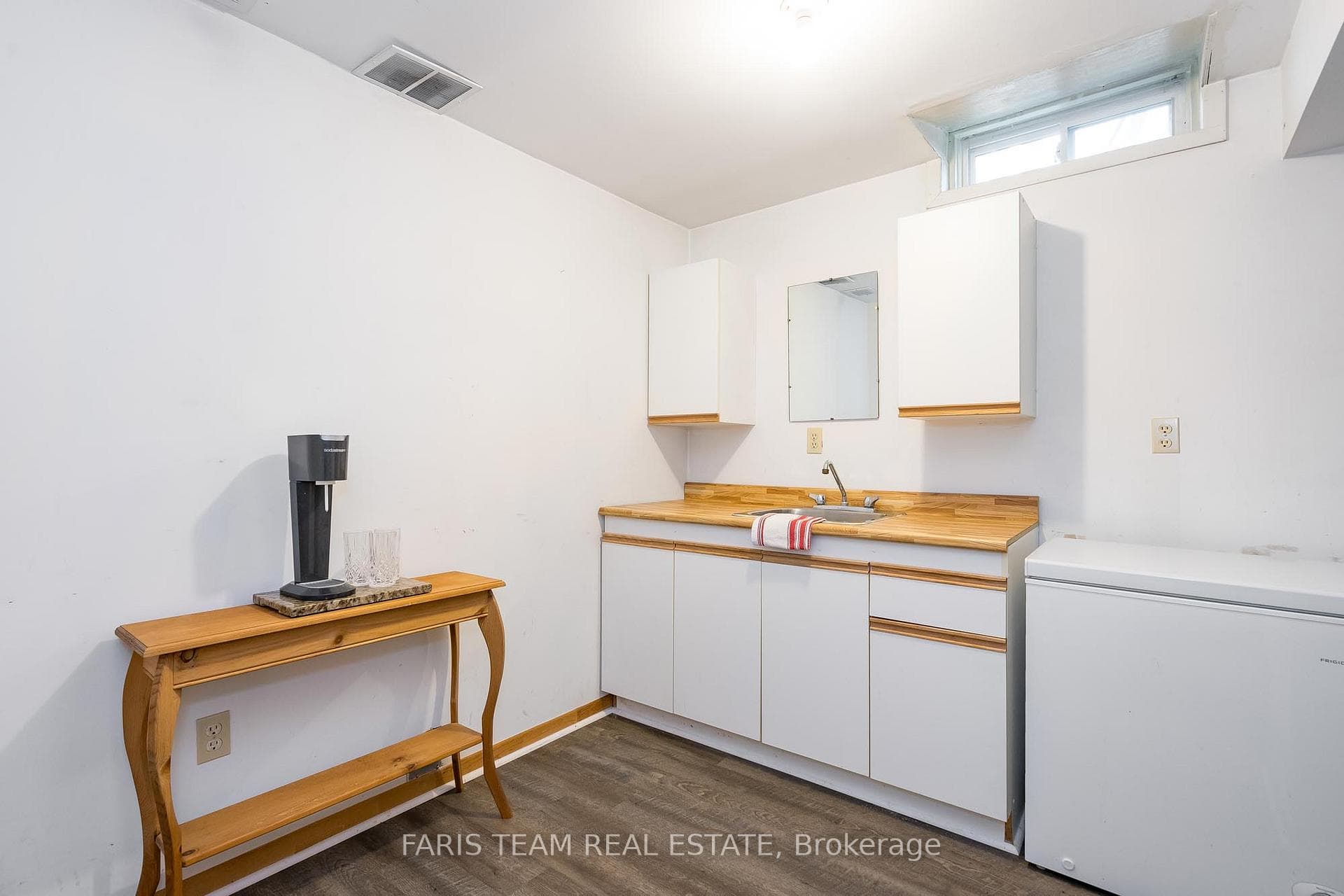 Kitchenette with vinyl floors, white cabinetry