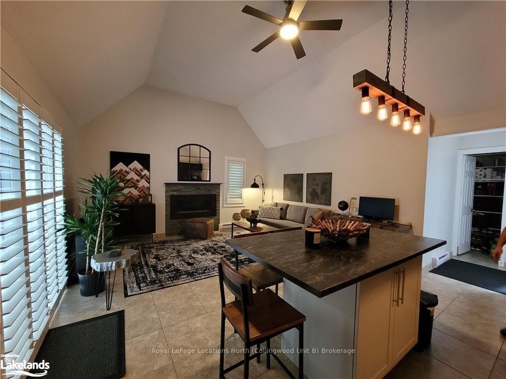 Kitchen featuring high vaulted ceiling, ceiling fa