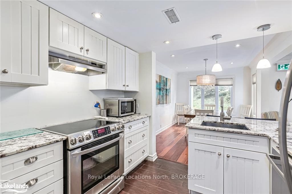Kitchen with white cabinets, hanging light fixture