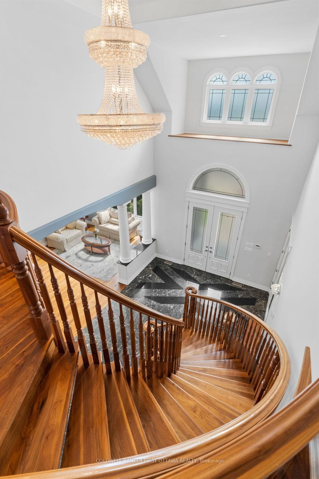 Grand staircase to the 2nd lvl w custom Chandelier
