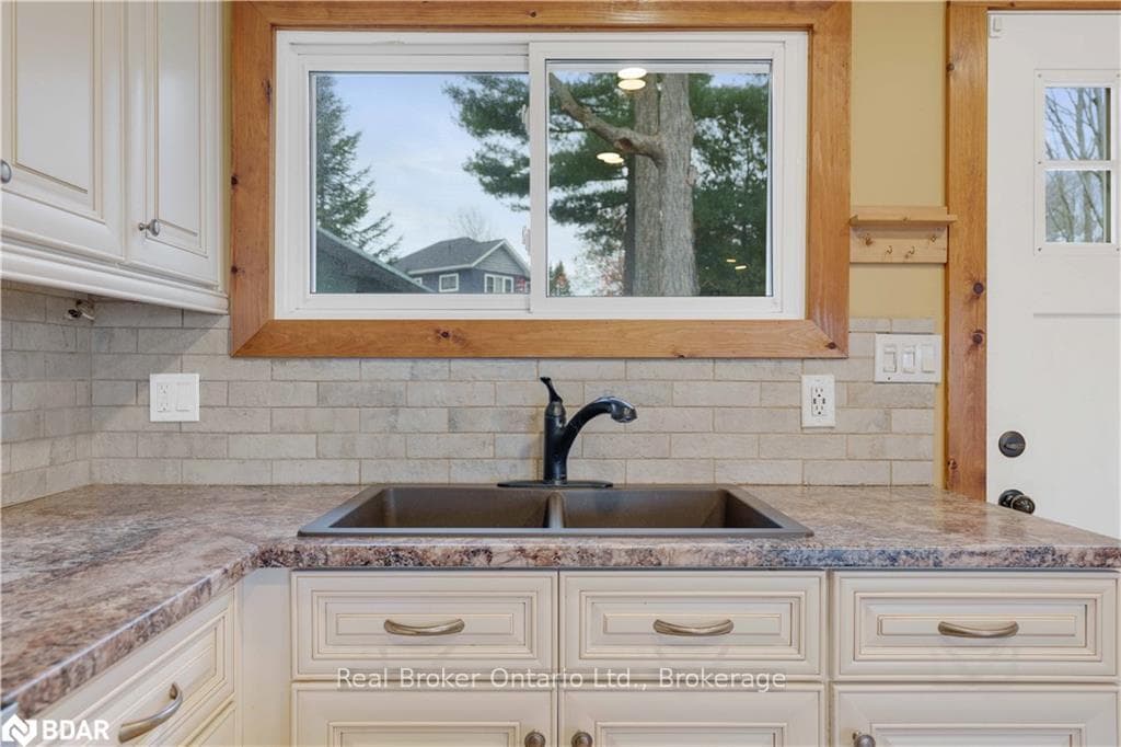 Kitchen featuring white cabinets, backsplash, and