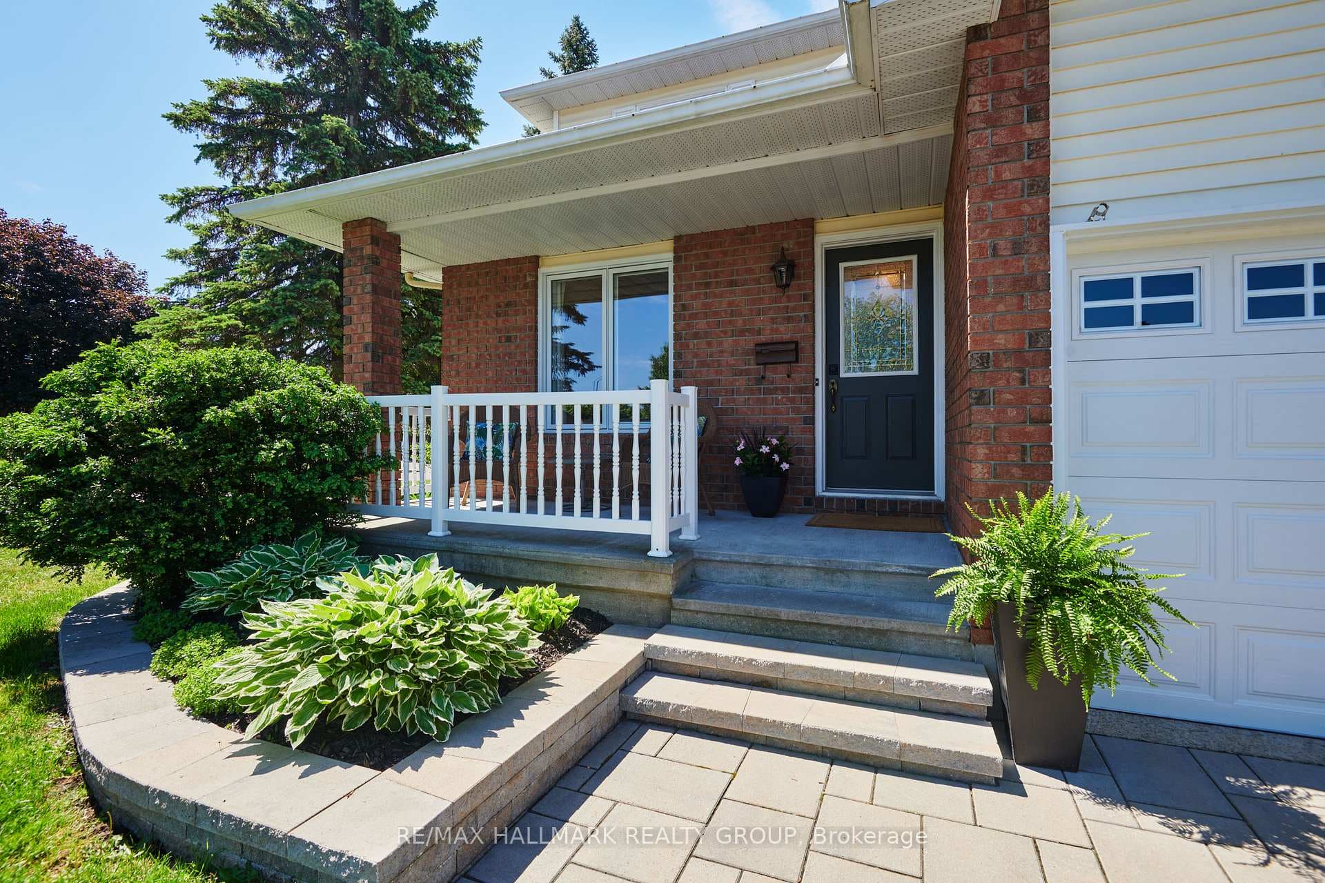 FRONT | interlock, covered veranda, landscaped
