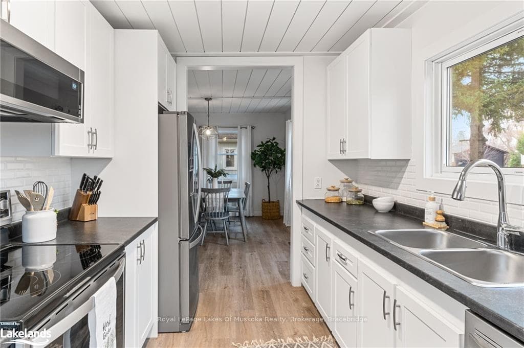 Kitchen featuring new laminate flooring, stainless