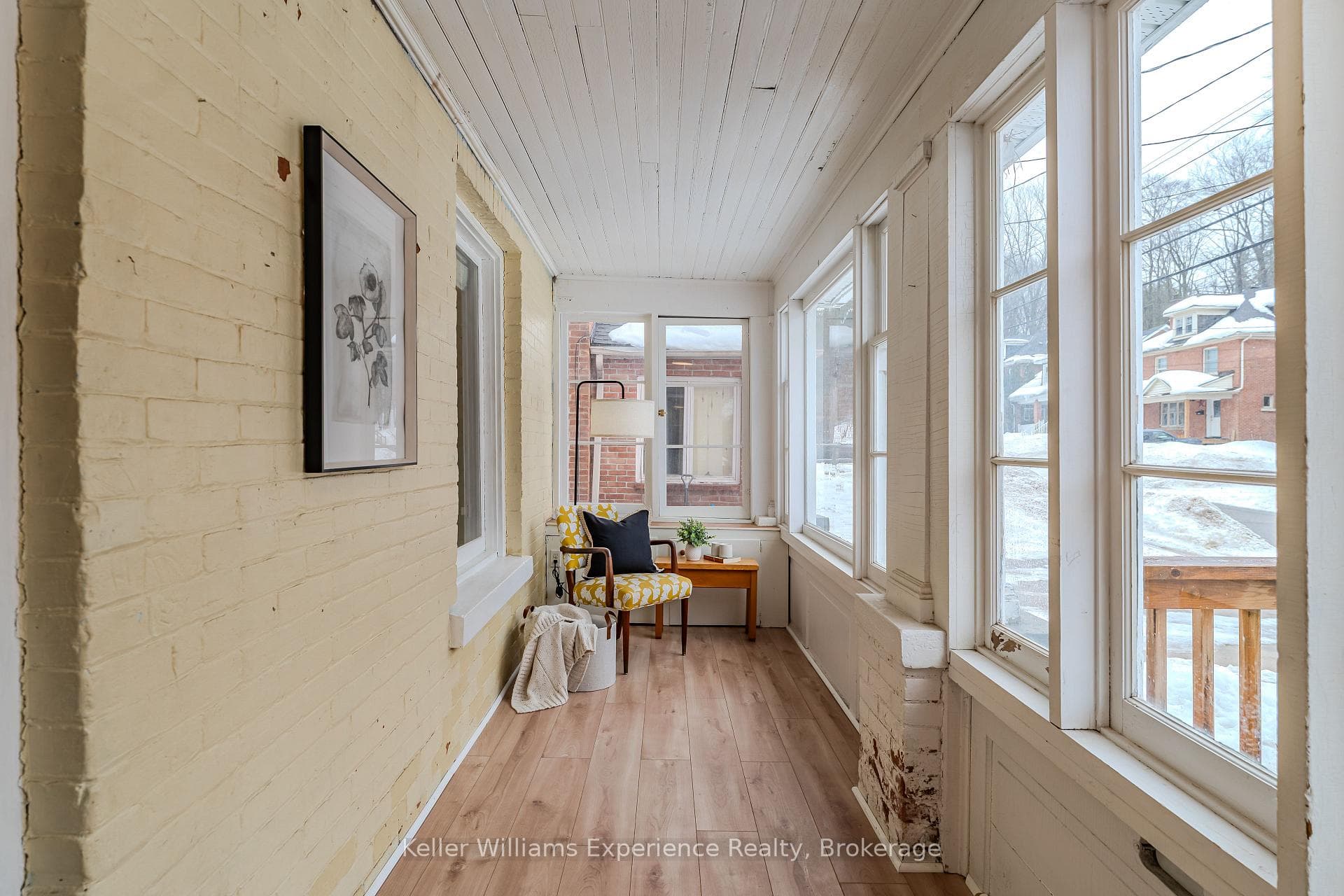 An enclosed sunroom stretches across the front