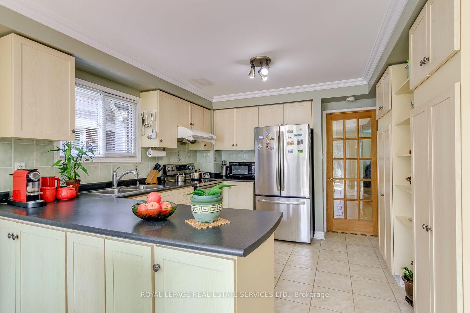 Kitchen Features Maple Wood Cabinetry and Pantry