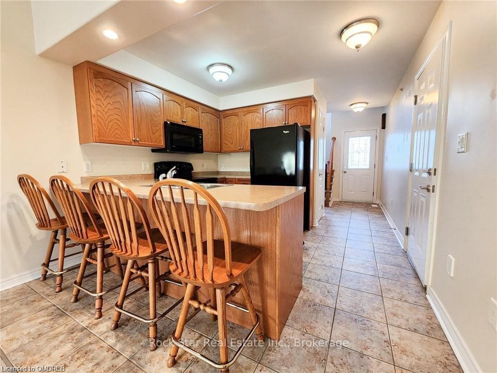 Kitchen with kitchen peninsula, black appliances,