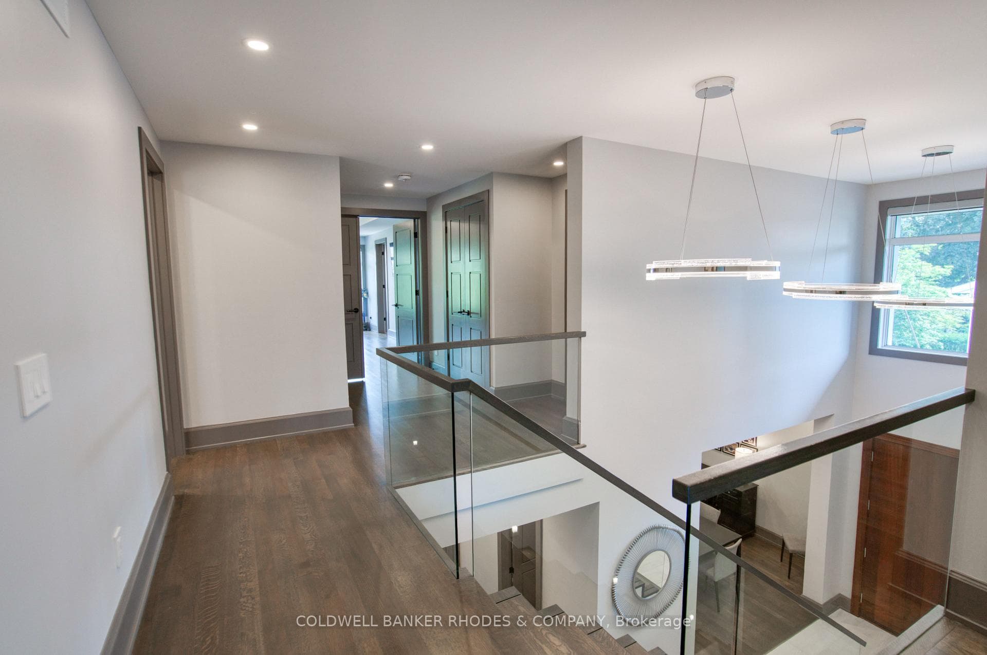 Upstairs hallway framed with glass railings.