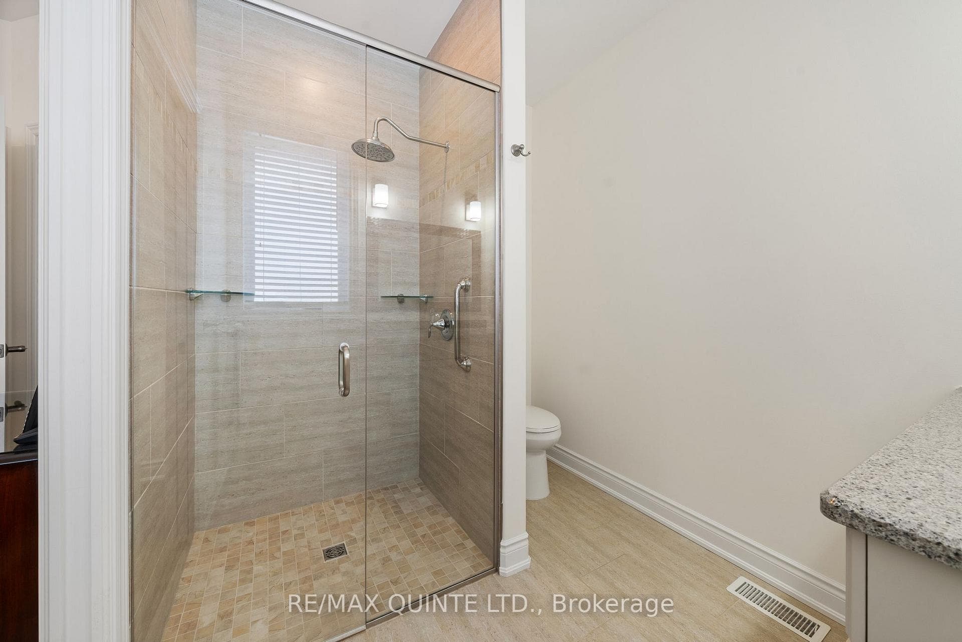 Primary ensuite walk-in glass-enclosed shower.