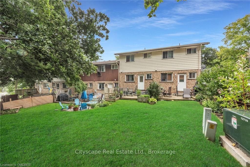 Back of property featuring a deck and a lawn