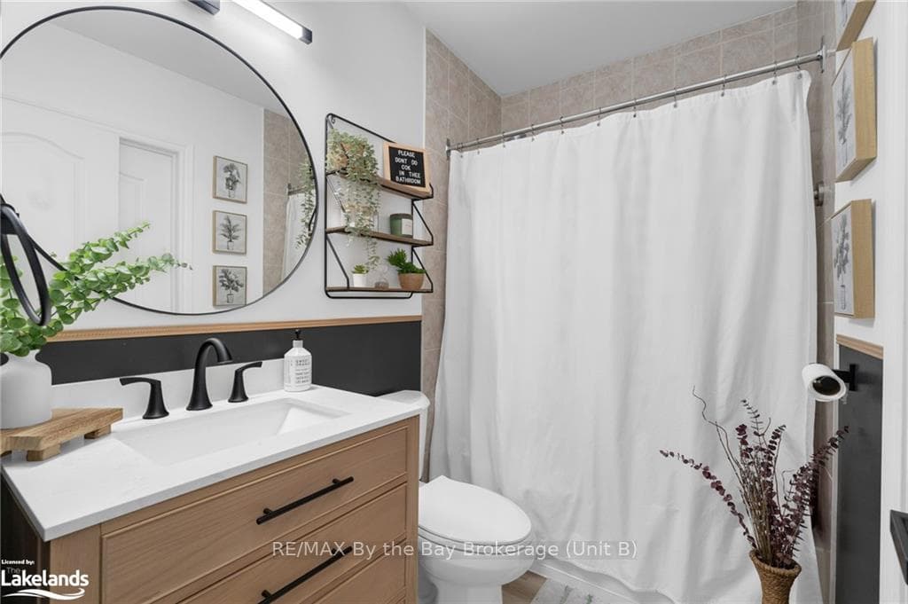Bathroom featuring vanity, toilet, and curtained s