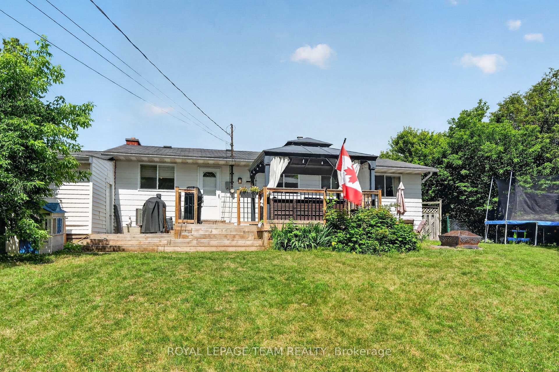 Huge rear deck overlooks fenced backyard.