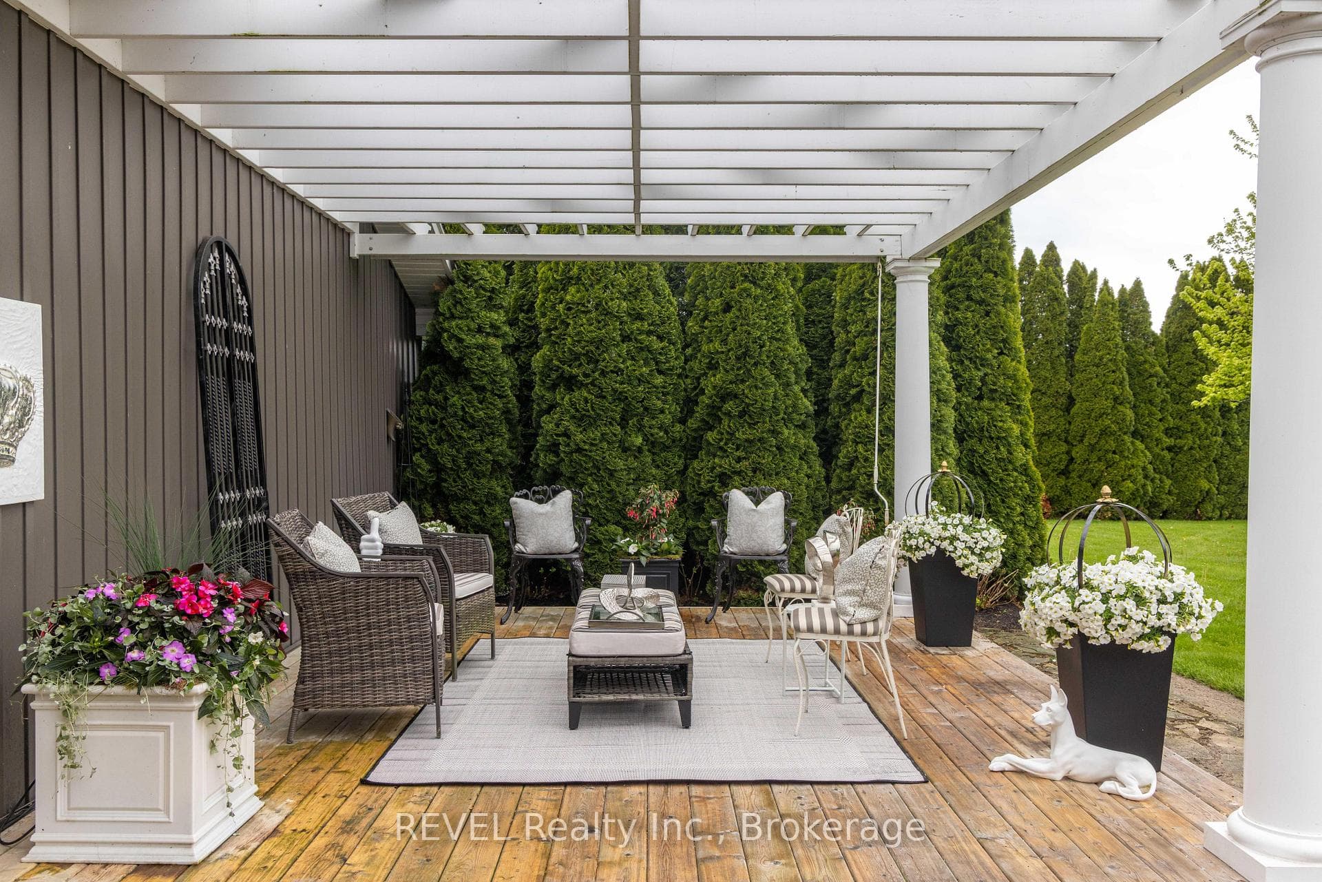 Large wooden deck with pergola in backyard.