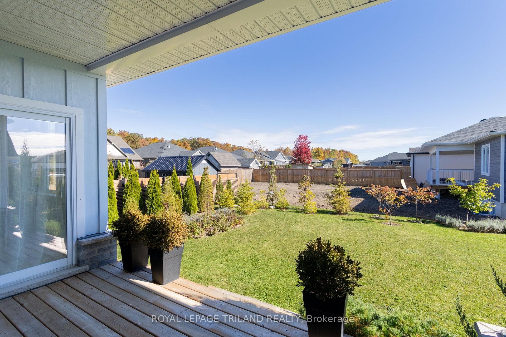 Sundeck overlooking mostly fenced-in yard
