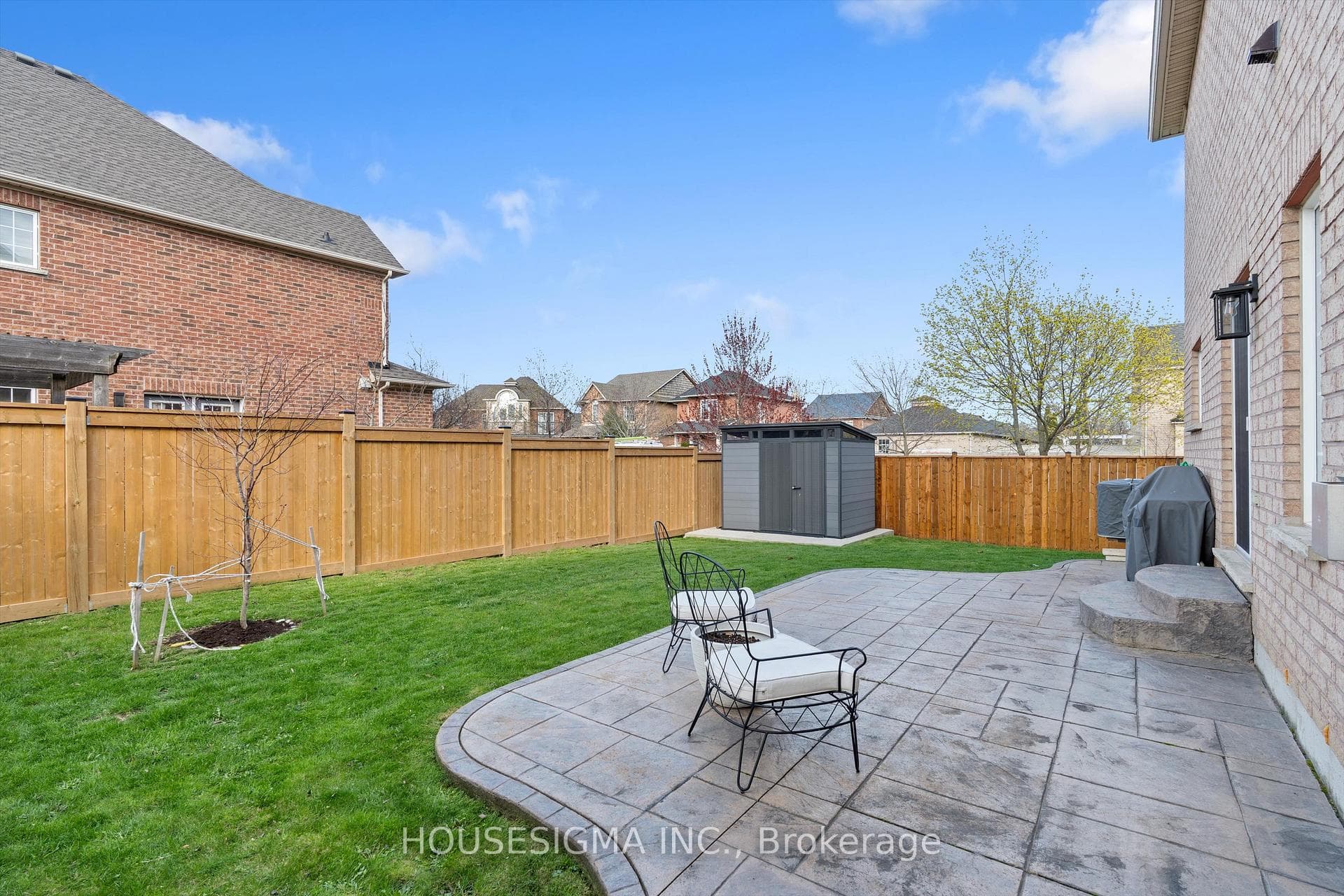 Backyard with stamped concrete patio and a shed.