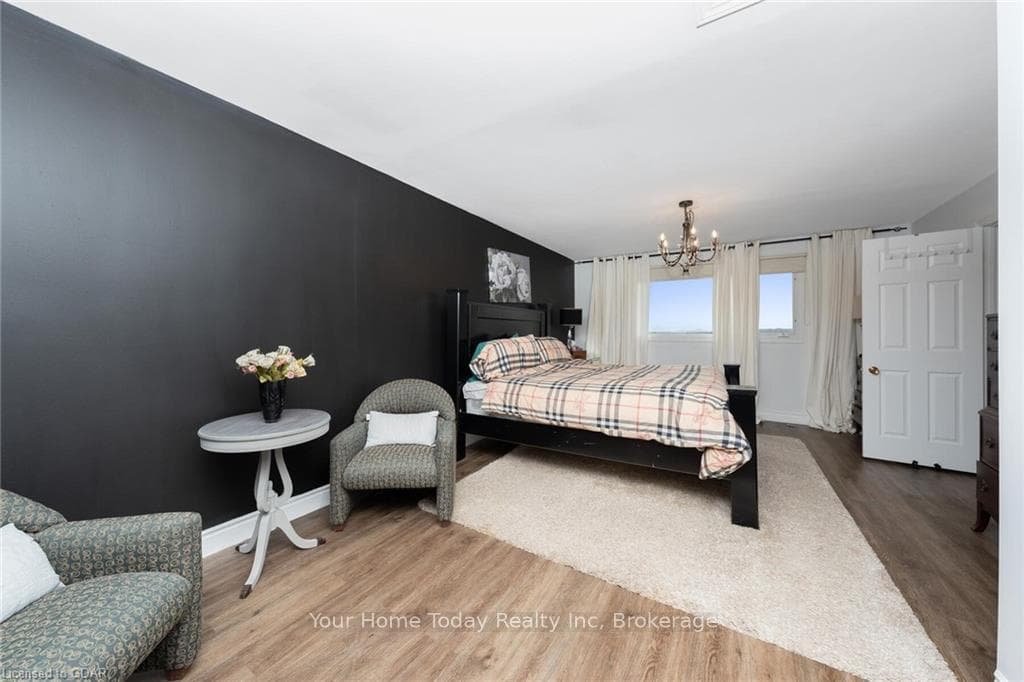 Bedroom featuring lofted ceiling, hardwood / wood-