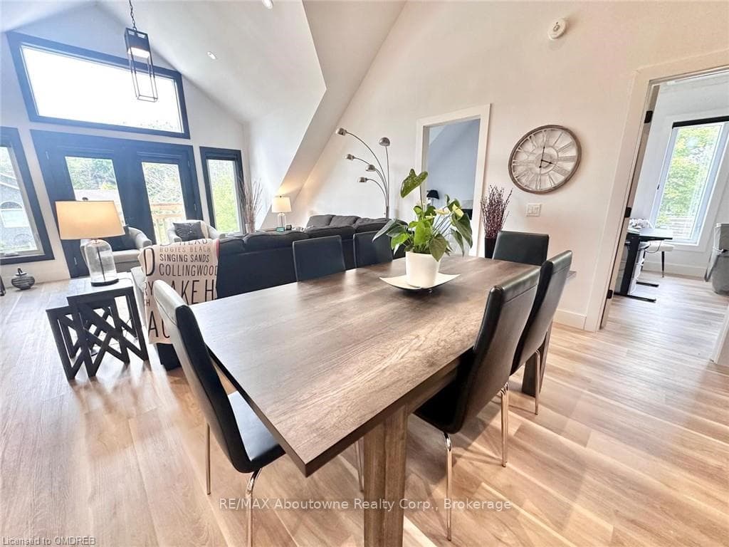 Dining space with high vaulted ceiling and light w