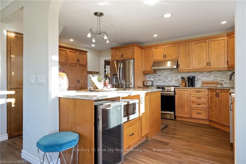 Kitchen with pendant lighting, wine cooler, dark h