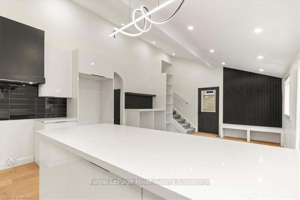 Kitchen featuring decorative backsplash, white cab
