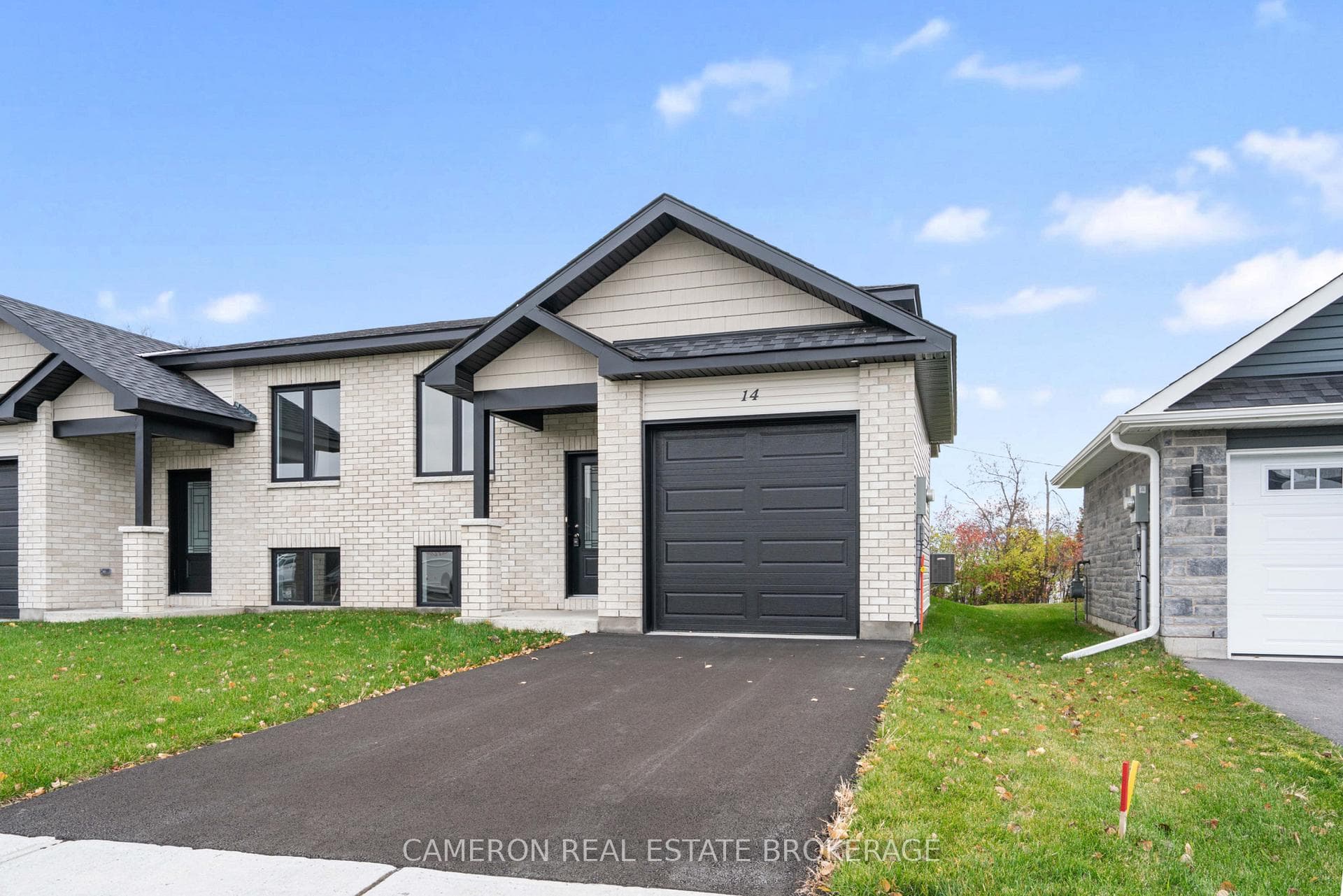Fall view with paved driveway & fully sodded lot