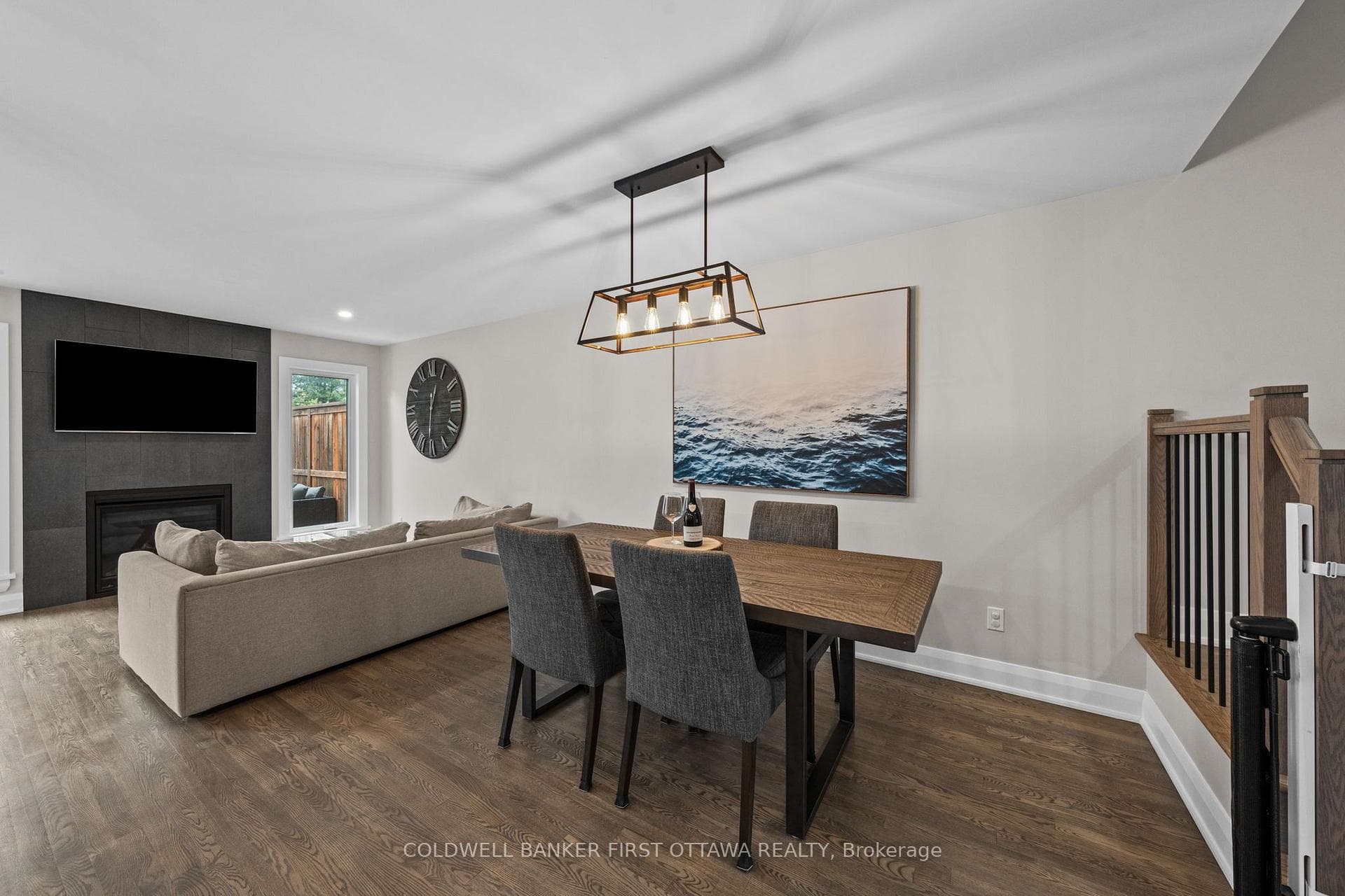Dining room w modern fixture above.