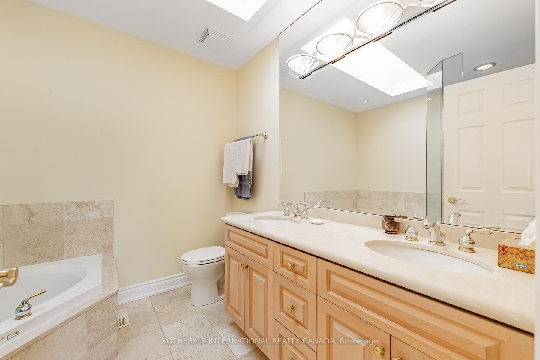 Luxurious ensuite w/ tub, shower, & dual vanities.