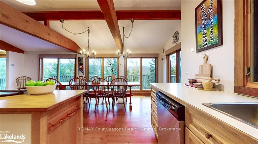 Kitchen with lofted ceiling with beams, light wood