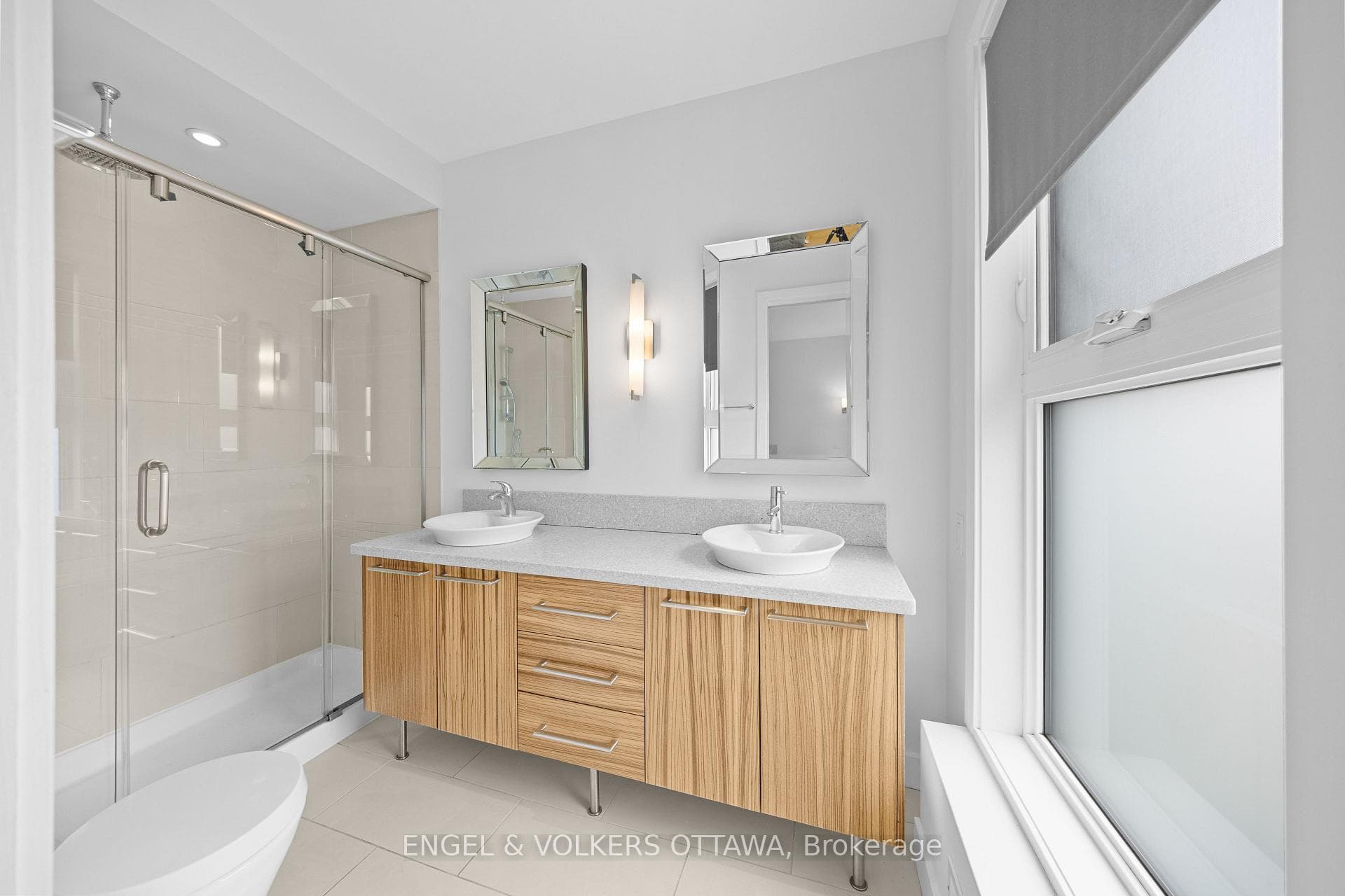 Primary ensuite with double sinks and glass shower
