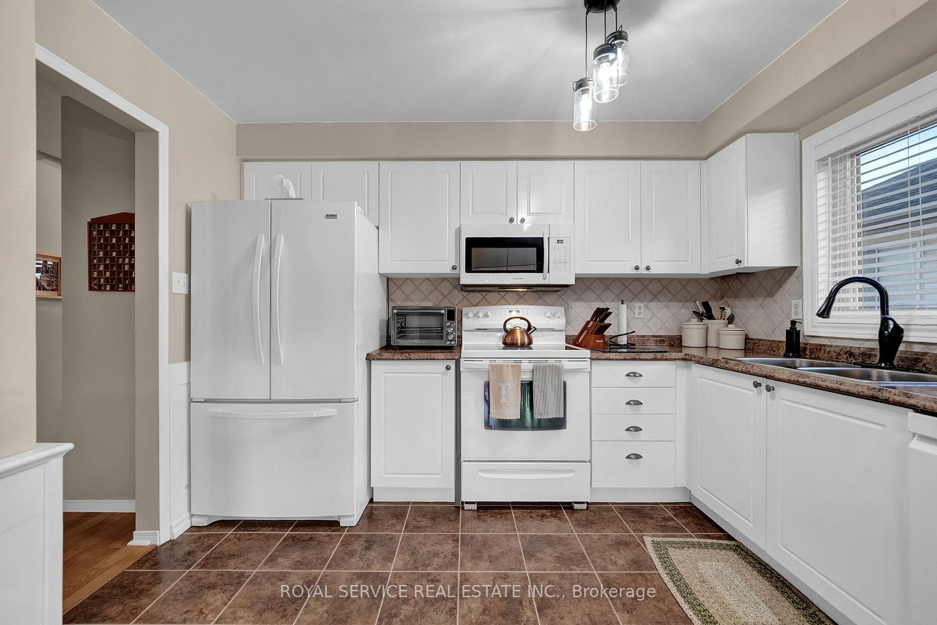 Pristine, timeless White Kitchen with backsplash.