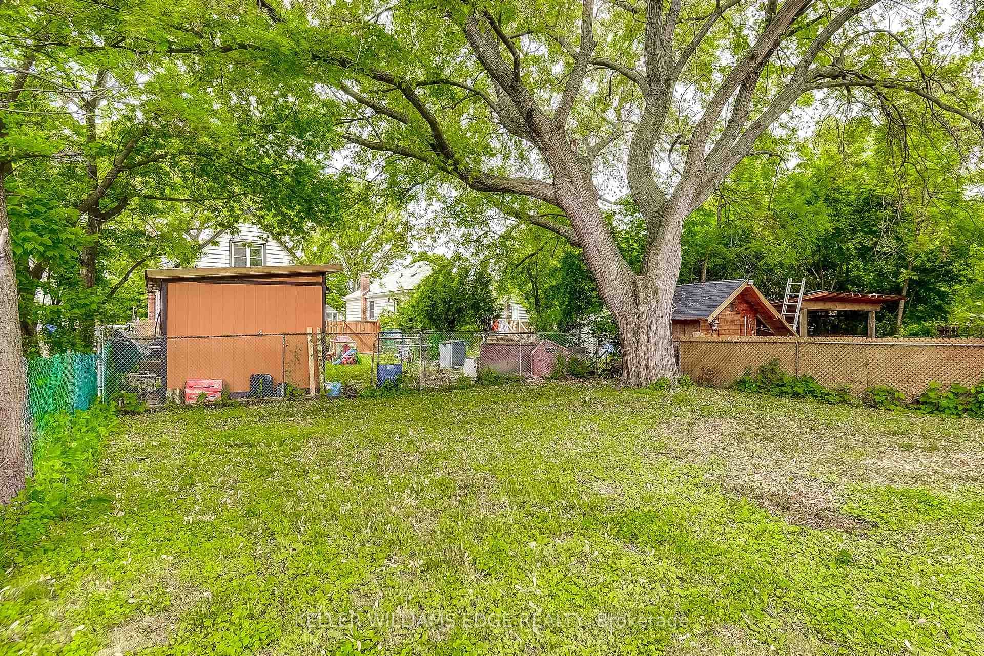 Fenced backyard featuring a shed