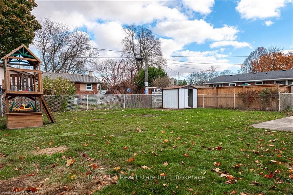View of yard with a storage unit and a playground