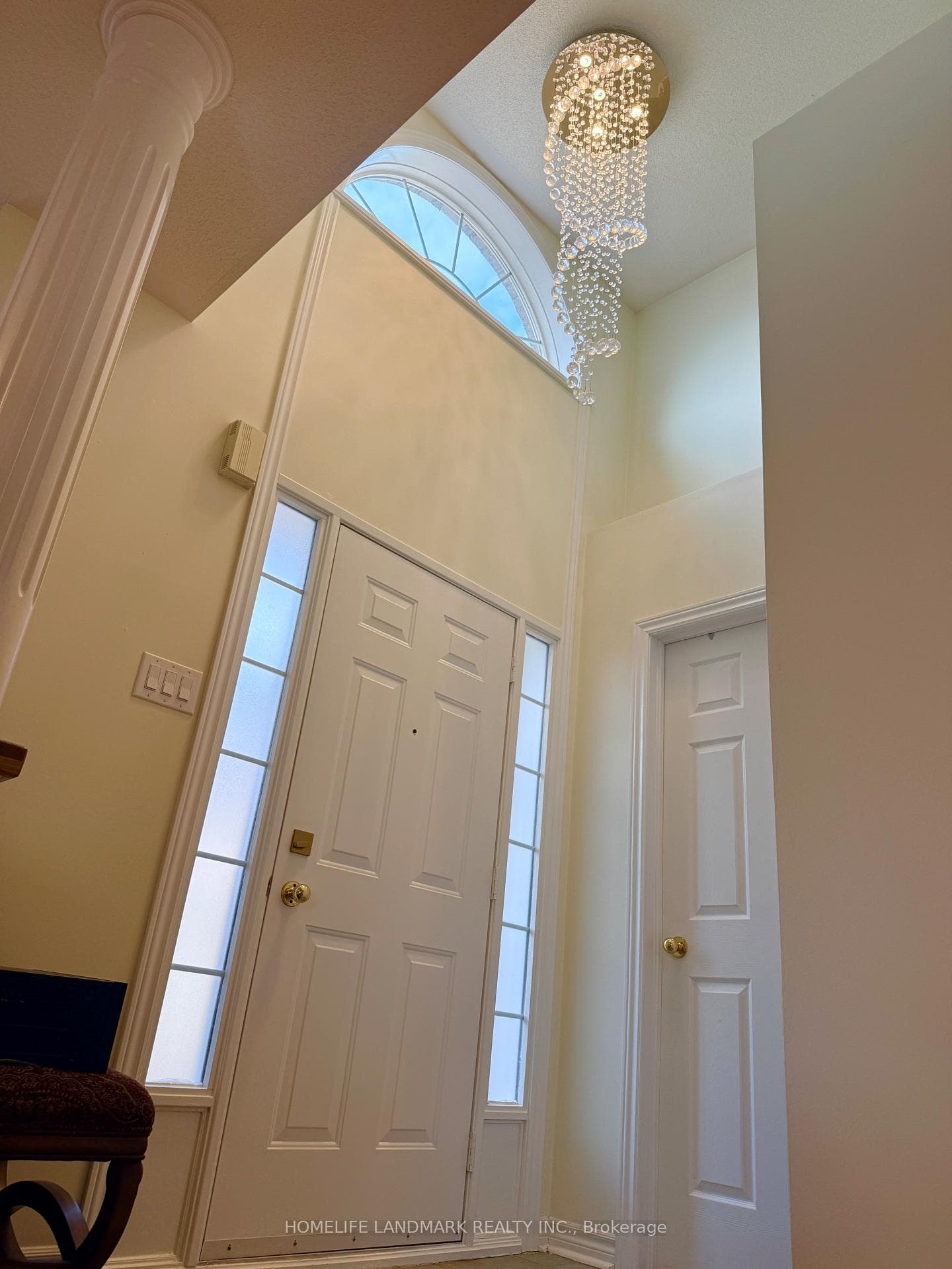 Foyer with vaulted ceiling and light fixture.