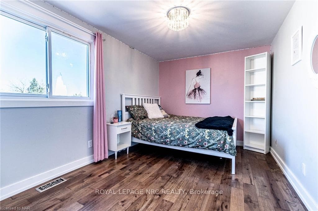 Bedroom with a chandelier and dark hardwood / wood