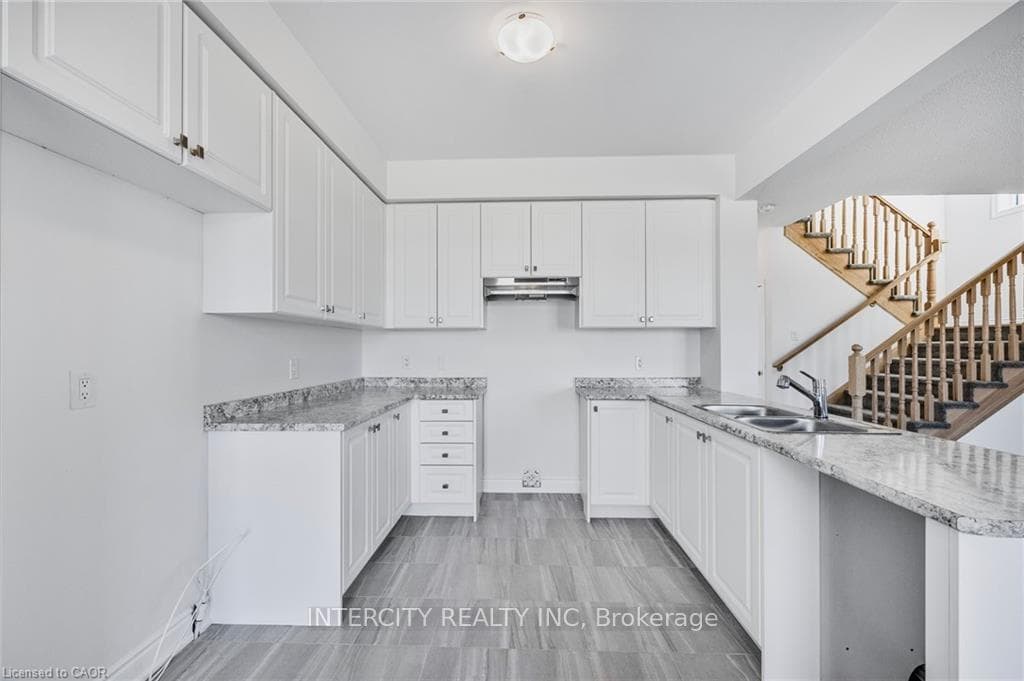 Kitchen with white cabinetry, sink, and kitchen pe