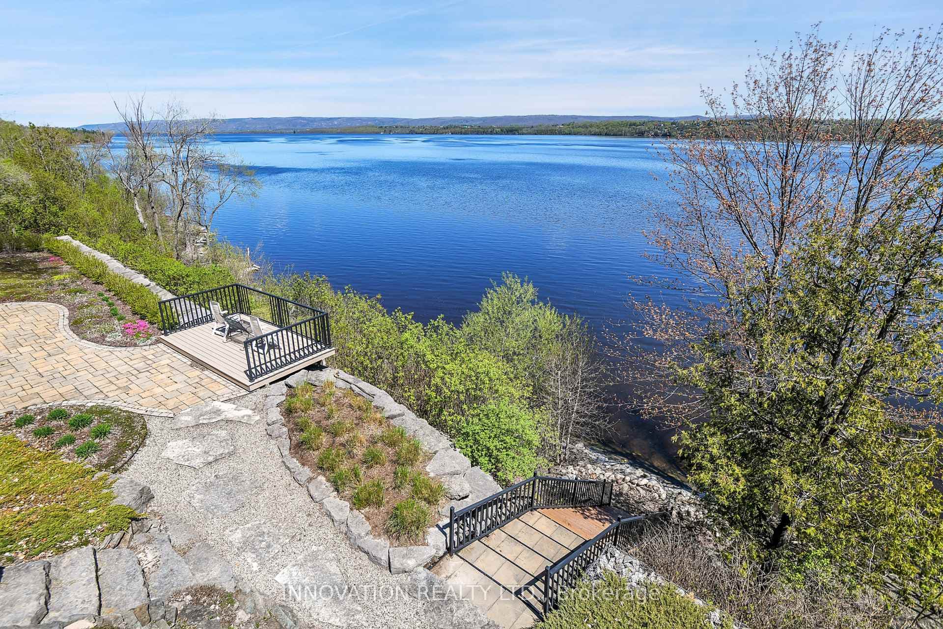 Extensive landscaping includes stairs to shoreline