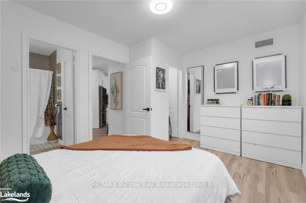 Bedroom featuring stainless steel fridge, light wo