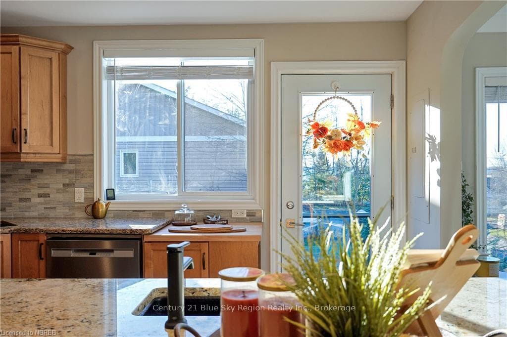 Kitchen with dishwasher, tasteful backsplash, ligh