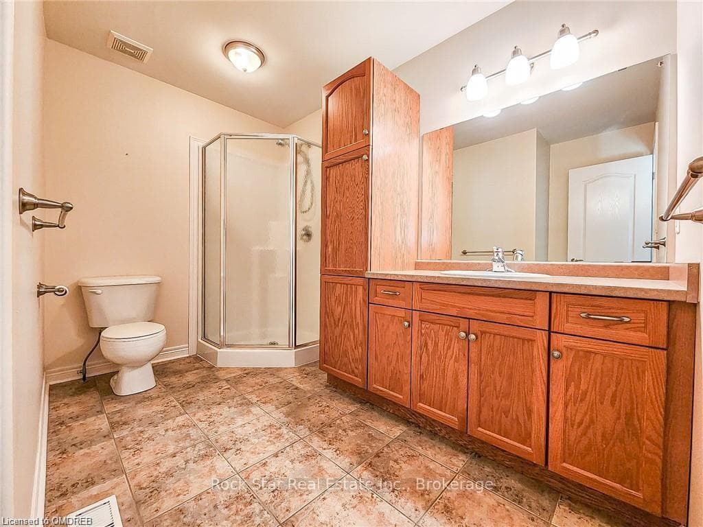Bathroom with an enclosed shower, vanity, and toil
