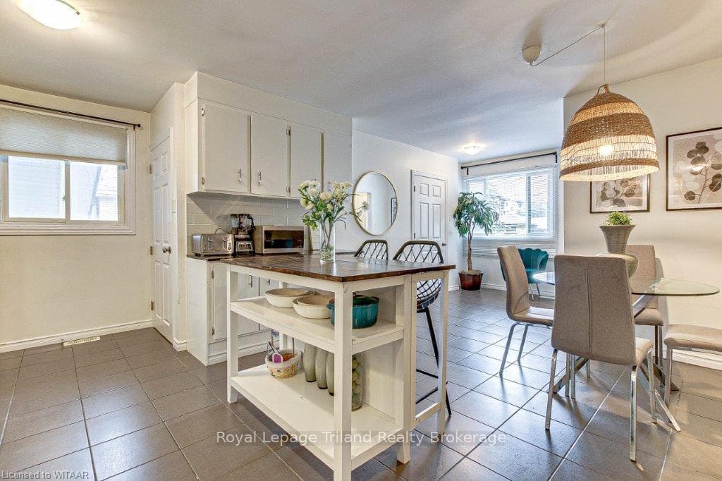Kitchen with white cabinets, pendant lighting, tas