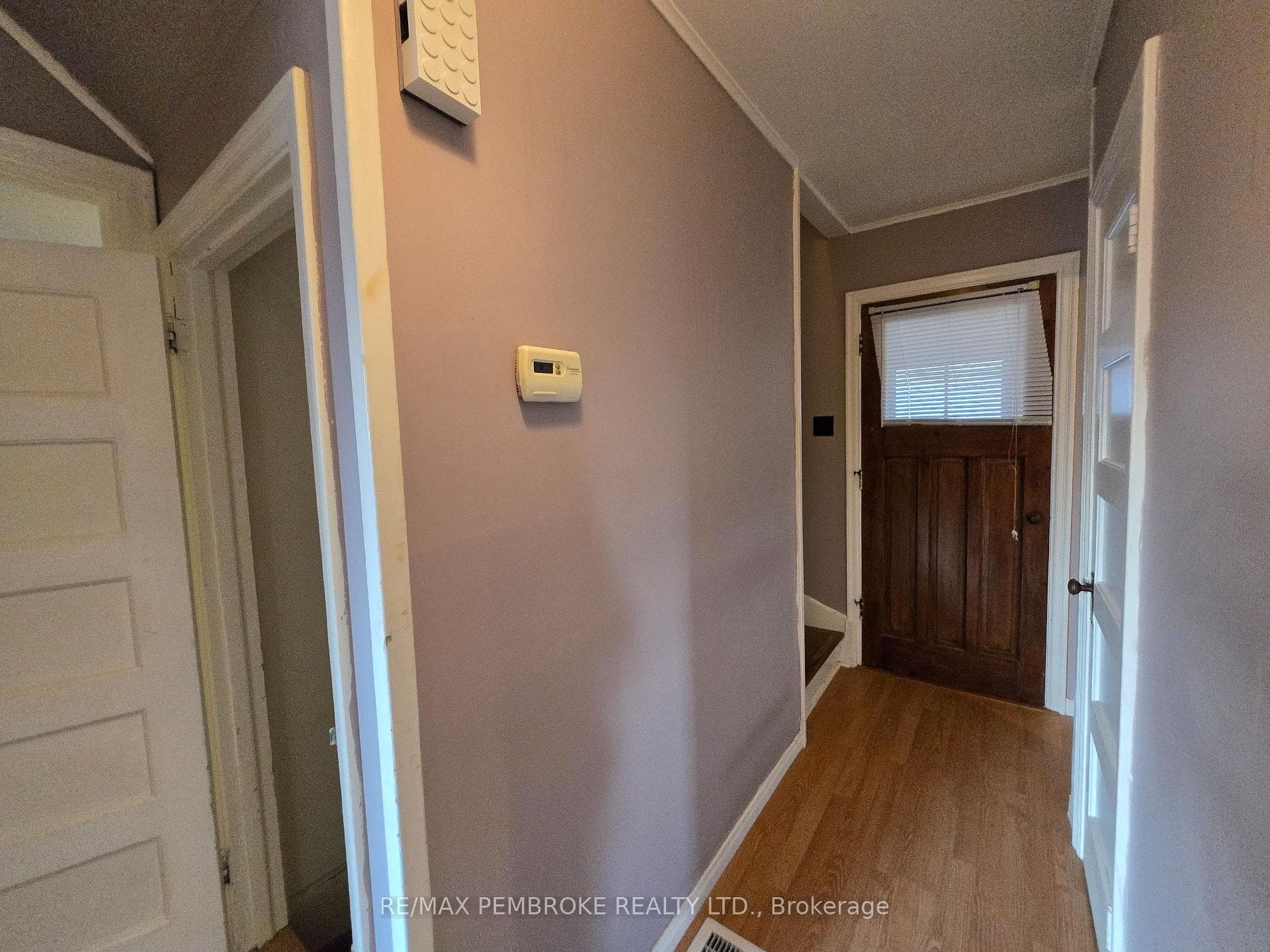 Hallway to foyer, bathroom, and stairs to 2nd leve