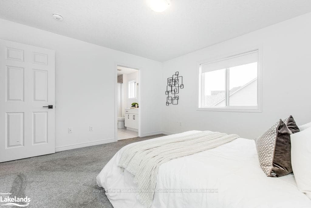 Bedroom with light colored carpet and ensuite bath
